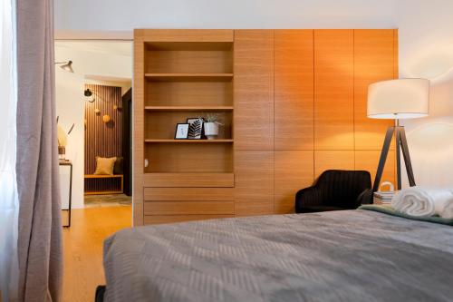 1 dormitorio con pared de madera, cama y silla en Historic Lodge in der Innenstadt Krems, en Krems an der Donau