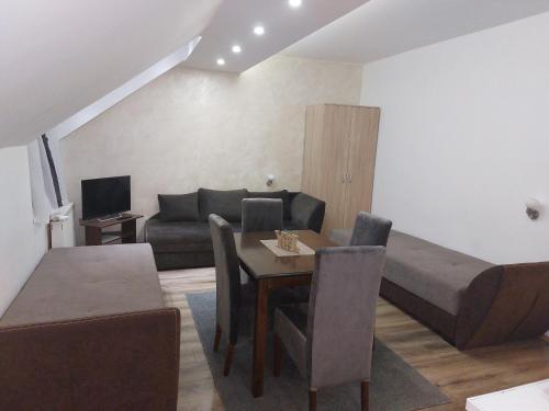 - un salon avec un canapé et une table à manger dans l'établissement Apartments Vila Djurdja, à Kopaonik