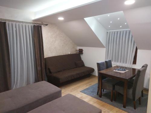 a living room with a couch and a table at Apartments Vila Djurdja in Kopaonik