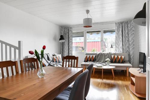 a living room with a wooden table and a couch at Sparkling modern house in Kista - close to city in Stockholm