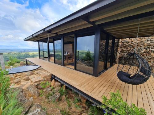 a house with a hammock on a wooden deck at Eagle View on Beumont in Dullstroom