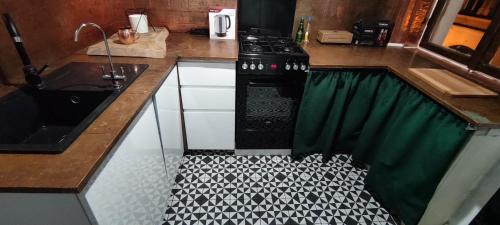 a kitchen with a black stove and a sink at Private Apartament Wroniecka 6 in Poznań