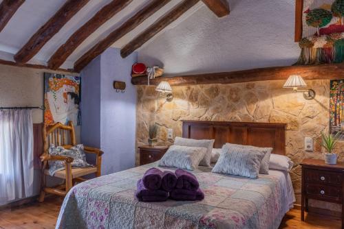 ein Schlafzimmer mit einem Bett mit lila Handtüchern darauf in der Unterkunft Casa Rural La Tahona in Elche de la Sierra
