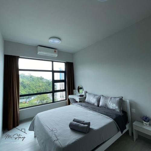 1 dormitorio con cama y ventana grande en MiStay 4-5PAX Luxury Suite Apartments en Kota Kinabalu