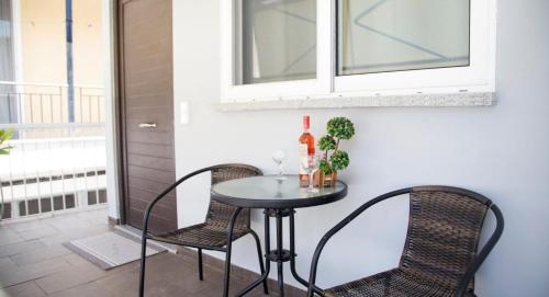 d'une petite table et de chaises sur un balcon avec une fenêtre. dans l'établissement Papatsas Center Houses, à Nydri