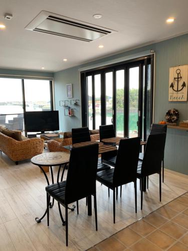 a living room with a table and chairs and a couch at Pier39 Uchiumi Cozy house located in front of the sea and harbor! in Miyazaki