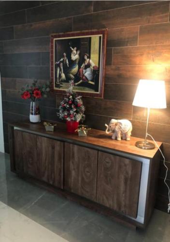 a table with a lamp and a painting on a wall at Palazzo Firenze in Naples