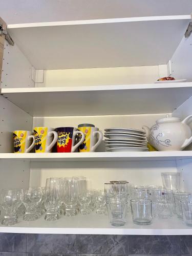 a shelf filled with cups and plates and glasses at Apartmanovy dům Bublajda in Bublava