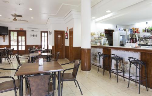 a restaurant with tables and chairs and a bar at Olympia Ronda Hostel in El Puig