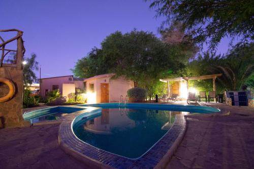 a swimming pool in a backyard at night at Hotel-Camping Takha Takha in San Pedro de Atacama