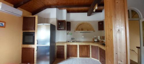 a kitchen with a stainless steel refrigerator and wooden cabinets at Vila Judita Žman in Žman