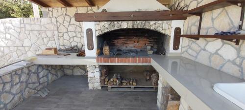 an outdoor kitchen with a brick oven in a house at Vila Judita Žman in Žman