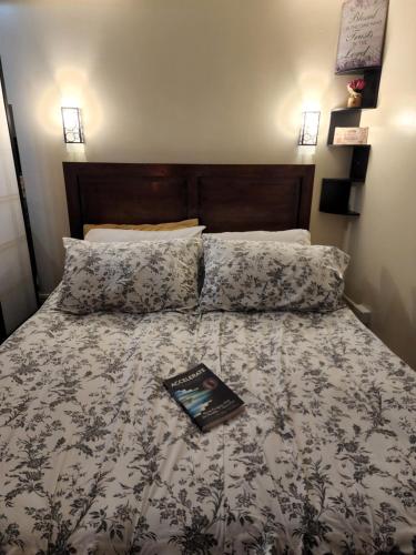a bedroom with a bed with a book on it at Lucky East Serin with Netflix DisneyPlus FreeCoffeeTea & Recliner in Tagaytay