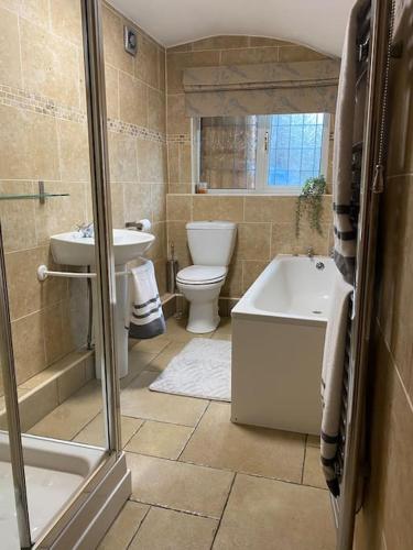 a bathroom with a toilet and a tub and a sink at Hidden Gem Canal Facing Retreat with lovely walks in Hopwas
