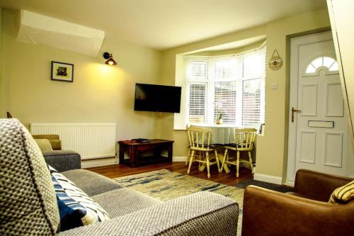 a living room with a couch and a table at Hidden Gem Canal Facing Retreat with lovely walks in Hopwas