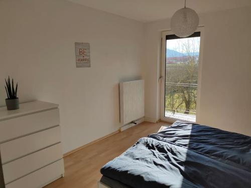um quarto com uma cama, uma cómoda e uma janela em Ferienwohnung ländlich und in Seenähe em Schörfling