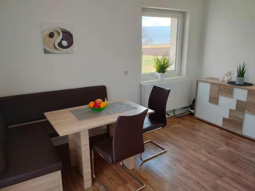 ein Esszimmer mit einem Tisch, Stühlen und einem Fenster in der Unterkunft Ferienwohnung ländlich und in Seenähe in Schörfling