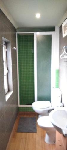 a bathroom with two toilets and a green window at Casinha de chocolate in Outeiro