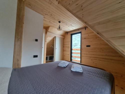 uma cama grande num quarto de madeira com uma janela em Vila Dalma em Divčibare