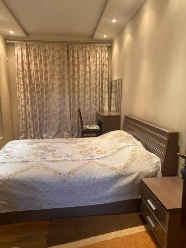 um quarto com uma cama grande e uma janela em Comfortable 2 rooms apt in Centre of Tashkent city em Tashkent