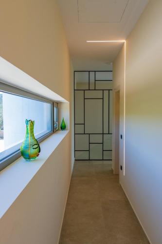 a hallway with a vase sitting on a shelf next to a window at Lemon Tree Villa in Gialova