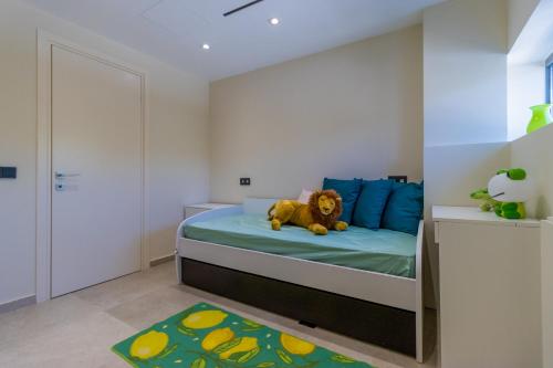 a bedroom with a bed with a teddy bear on it at Lemon Tree Villa in Gialova