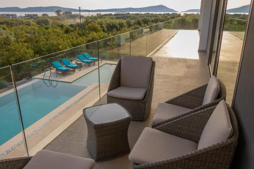 a balcony with chairs and a swimming pool at Lemon Tree Villa in Gialova