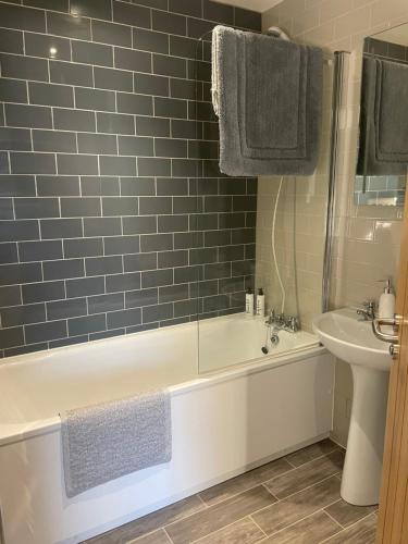 a bathroom with a white bath tub next to a sink at The Red Lion Charing Heath in Charing