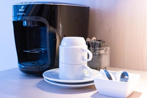 a coffee maker sitting on a counter next to a microwave at Taste Hotel Hockenheim in Hockenheim