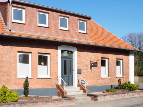 a red brick house with a blue door at Ferienwohnung Alte Bäckerei Werlte in Werlte