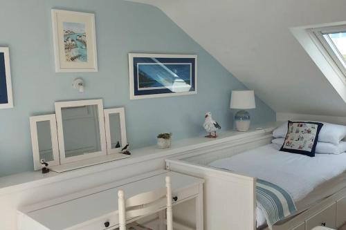 a white room with a bed in a attic at Sea Crest, Beautiful home in Tenby with sea views in Pembrokeshire