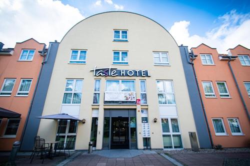 a large building with a sign on the front of it at Taste Hotel Hockenheim in Hockenheim