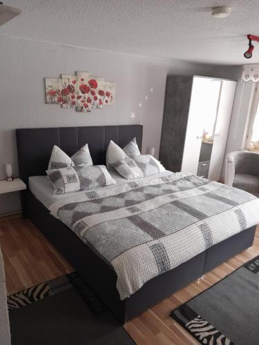 una camera da letto con un letto grande con cuscini sopra di Haus Hubertus a Stolberg i. Harz