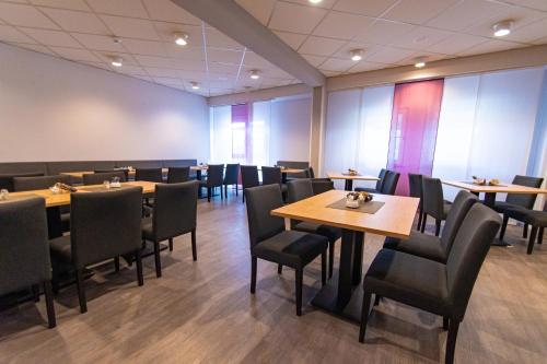 a dining room with tables and chairs at Taste Hotel Hockenheim in Hockenheim
