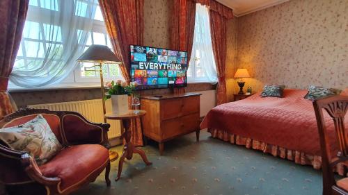 a bedroom with a bed and a chair and window at Podewils Old Town Gdansk in Gdańsk