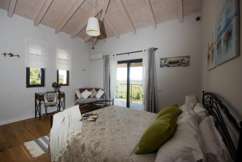 a bedroom with a bed and a room with a balcony at Villa Sania in Kassiopi