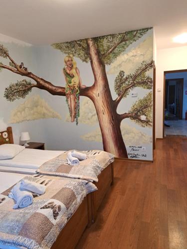 a bedroom with a painting of a woman sitting on a tree at Casa Paduricea in Dezmir
