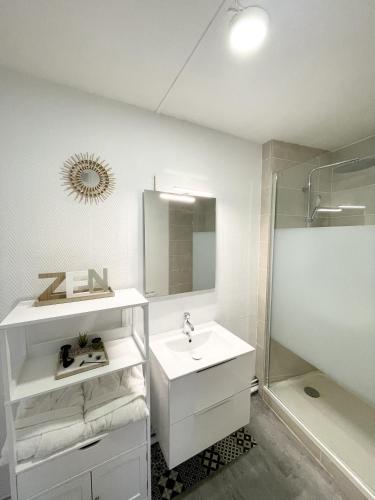 une salle de bain blanche avec un lavabo et une douche dans l'établissement Le Corbusier - Cosy & SPA - Appartement, à Firminy