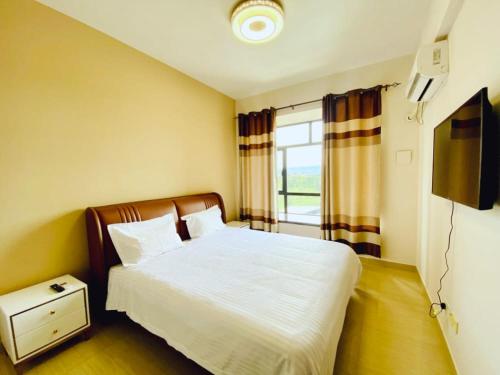 Century Park Hotel & Residences في كيغالي: غرفة نوم صغيرة بها سرير ونافذة