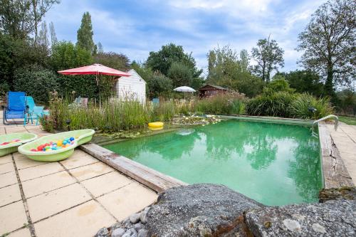 Saint-Paul-en-Gâtine的住宿－Au Cocorico，一座小游泳池,在院子里有船