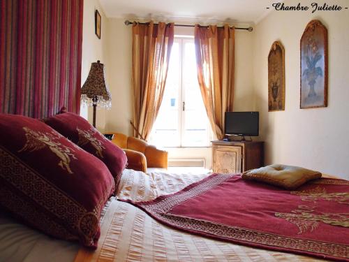 a bedroom with a large bed and a window at Hotel Le Saint Laurent in Saint-Laurent-des-Arbres