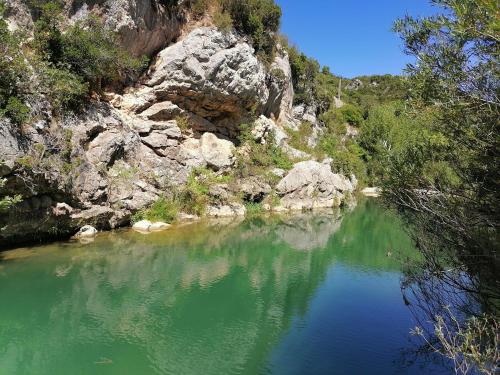 une masse d'eau à côté d'une falaise rocheuse dans l'établissement Villa Ripaud, private river swimming, hot tub, à Villesèque-des-Corbières
