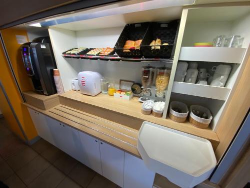 a kitchen with a counter with food in it at Hotel Class'Eco Carcassonne in Carcassonne