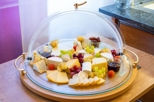 a plate of cheese and fruit on a table at Taste Hotel Hockenheim in Hockenheim
