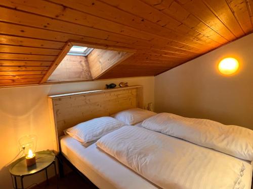 Cama grande en habitación con techo de madera en Apartmenthaus Rapplhof en Haus im Ennstal