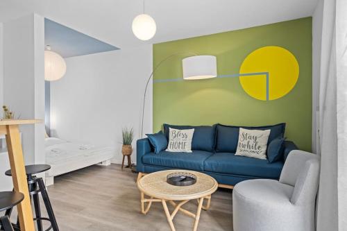 uma sala de estar com um sofá azul e uma parede amarela em Grünes Wohnen in Düren em Düren - Eifel