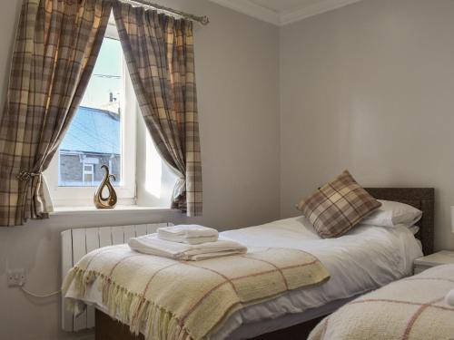 a bedroom with two beds and a window at Meadow View Cottage in Stanhope