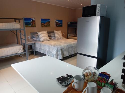 a room with two beds and a refrigerator at SONHOS dreams Self catering Garden Cottages in Bloemfontein