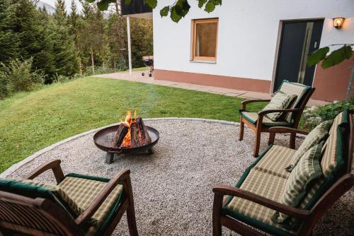 a fire pit in the middle of a yard with chairs at Ferienwohnung Waldgarten in Leiten