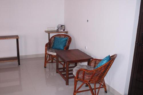 a room with three chairs and a table and a table at Coorg Happy Estate Stay in Madikeri